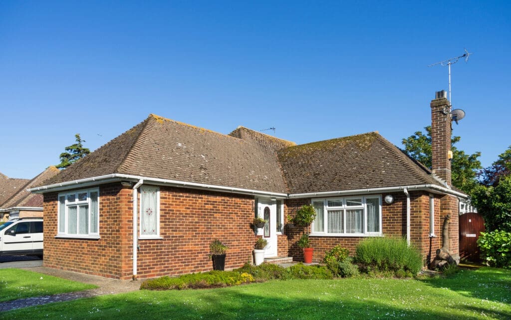 A residential brick built bungalow home with a tiled roof built in 1955 and updated to include uPVC windows